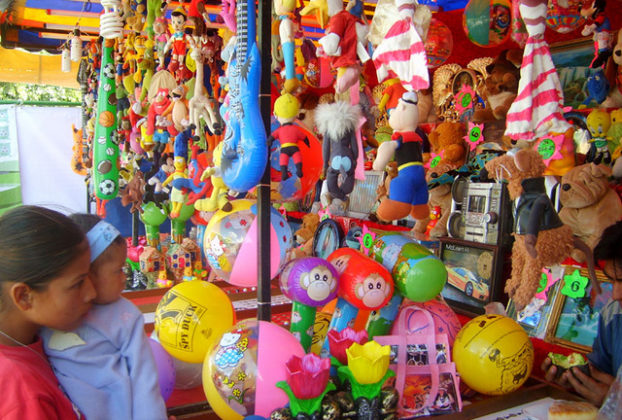 Located about 50 kilometers southwest of the state capital of Aguascalientes, the town of Calvillo hosts an annual guava fair. Stalls selling food and merchandise appear in the plaza. This one, filled with toys, entices a little girl and her baby sister. © Diodora Bucur, 2009