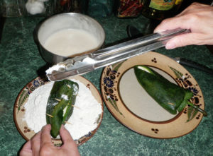 Dip stuffed chiles in flour to coat them so the egg batter will adhere. © Daniel Wheeler, 2010