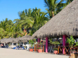 Palapa or thatch roofed restaurants line the beach in Mexico's Playa San Francisco. Known as "San Pancho," the town on the Nayarit Riviera boasts beaches of exceptional beauty. © Christina Stobbs, 2009