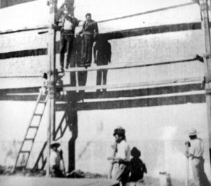 This 1937 photo shows architect Luis Barragan (left) and Jose Clemente Orozco on a scaffold in front of the Eight Beatitudes in Amatitan, Jalisco. The shadows indicate that Orozco did not have a left hand. Wording behind his head translates: Blessed are the peacemakers, for they shall be called the children of God. Photo courtesy of Ezequiel Garcia. © Ezequiel Garcia, 2010