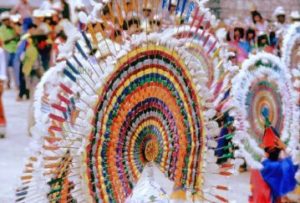 Frances Toor described the Quetzal dance headdress as a "huge wheel, over five feet in diameter, with colored paper or silk ribbons interlaced through a network of slender reeds with a border of lovely feathers... attached to a conical cap on the head of the dancer, held by a ribbon or kerchief tied under the chin." © Tony Burton, 2004