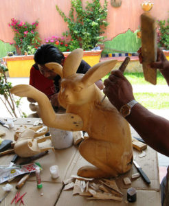 Oaxaca artisan Jacobo Angeles works on a piece while an uncle in the foreground also carves; his project is a lifelike rabbit. © Alvin Starkman 2008