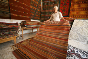 Master weaver Porfirio Santiago from Teotitlan del Valle, Oaxaca, displays some of his rugs and tapestries. © Alvin Starkman 2007