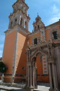 La Nuestra Señora de la Soledad Sanctuary features ornate carvings and horseshoe shaped arches framing the entranceway and the niches that house statues of saints.