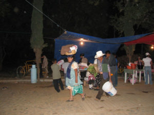 Indigenous women carry their food and flowers to the pueblo cemeteries in the traditional way -- in baskets balanced on their heads.