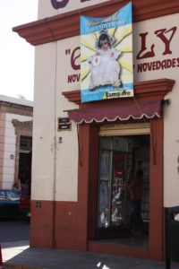 Toward the end of January, signs like this one are seen all over Oaxaca, inviting patrons into stores to buy clothing for the Baby Jesus images. The occasion is the Dia de la Candelaria, or Candlemas. It commemorates little Jesus' presentation in the temple, according to Hebrew custom. In Mexico, the image of the Christ child from the family's nativity scene receives new clothing for Candlemas © Tara Lowry, 2014