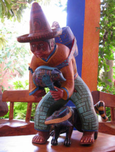 This man wears an old fashioned Mexican sombrero and carries a basket on his back. Jacobo Angeles creates one of a kind wood sculptures. © Alvin Starkman 2008