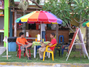 Waiting for Los Abuelos restuarant to open, its waiters befriend the dog. The restaurant in Tecolutla, Mexico, is a 1950s-style hamburger hut. © William B. Kaliher, 2010