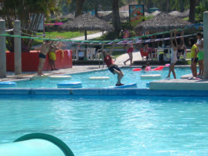 This pool has floating pads that are connected to the bottom of the pool. Overhead bars are mounted above them for people to hold as they cross the water without falling in. This is a fin way pass the day under the hot Mexican Sun. © Julia Taylor 2008